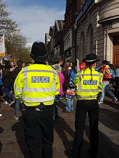 Back of Male and Female Officers at Football