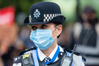 Photo of female police officer wearing a face covering in a public place