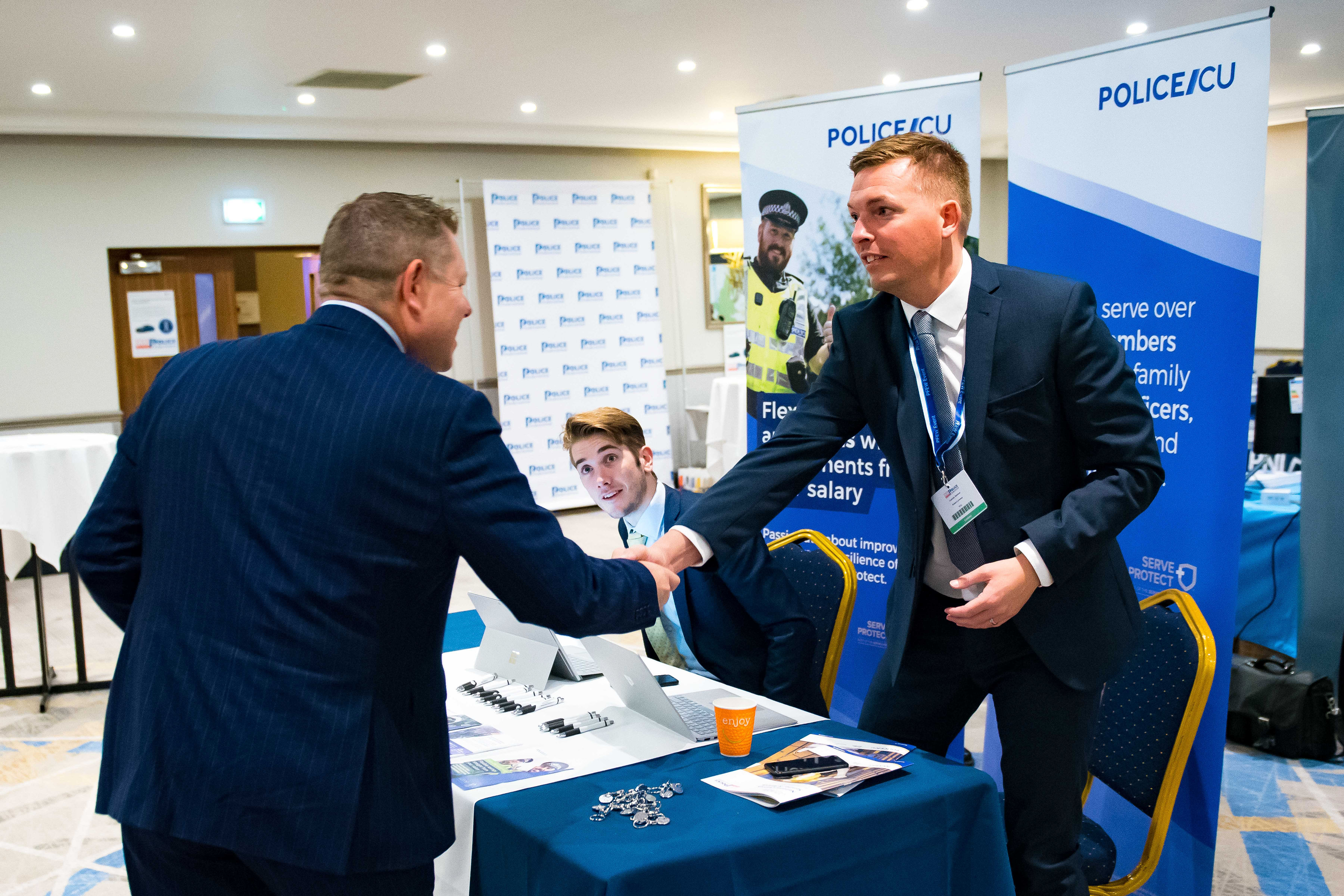 PFEW Chair John Apter (left) greets an exhibitor at the Custody Seminar, one of several events put on by PFEW this year